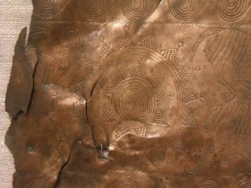 A solar disc design on a bronze metal sheet